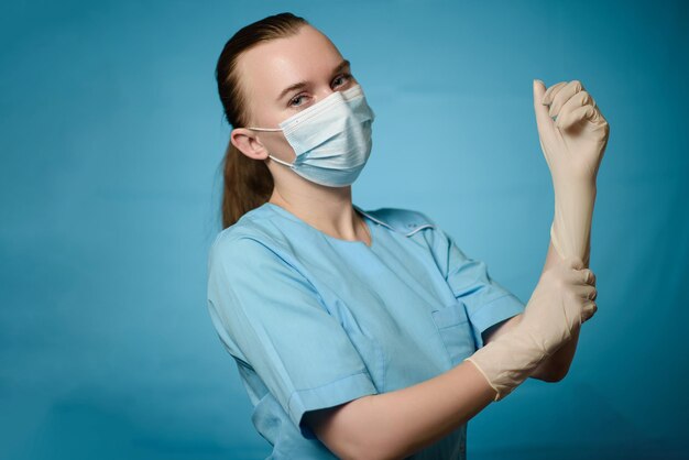 Un médecin portant un masque médical met des gants sur ses mains