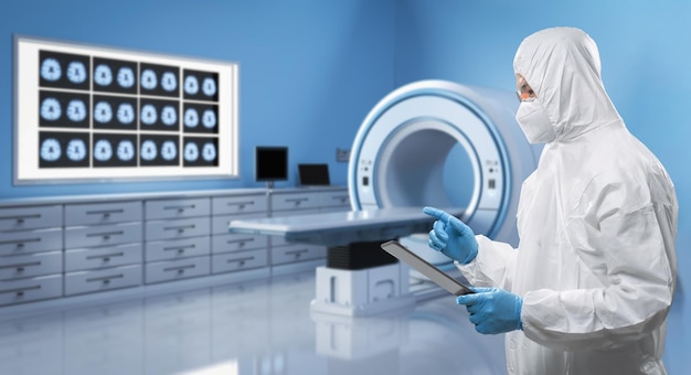 Le médecin porte une combinaison de protection médicale ou une combinaison avec un cerveau à rayons x et une machine à scanner irm