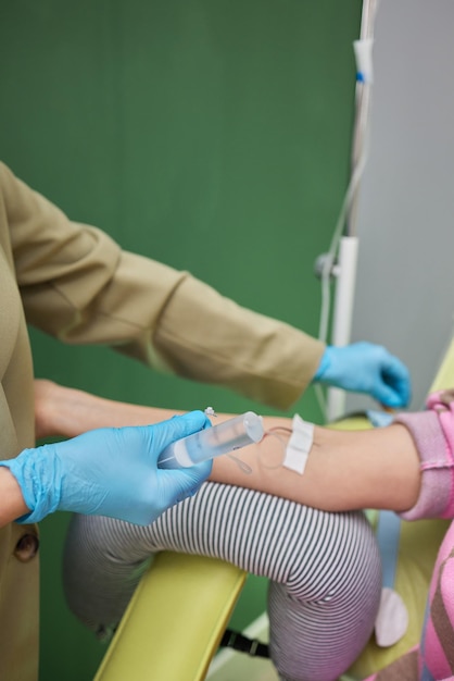 Médecin prélevant un échantillon de sang du bras pour un test sanguin en gros plan Technicien phlébotomiste prélevant du sang pour tester l'infestation par la maladie du coronavirus COVID19 Concept de soins de santé et de médecine