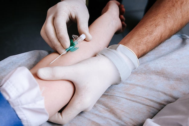 Un médecin prélève du sang d'une veine pour analyse par un patient dans un hôpital