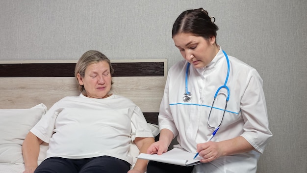 Le médecin prend des notes en écoutant les plaintes d'une patiente