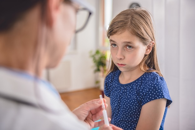 Un médecin prépare un vaccin à injecter à un patient