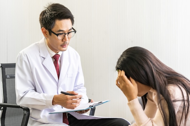 Médecin psychothérapeute visite maison de patience travaillant avec une femme asiatique déprimée