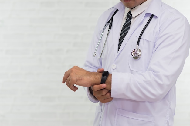 Médecin à la recherche de smartwatch sur blanc