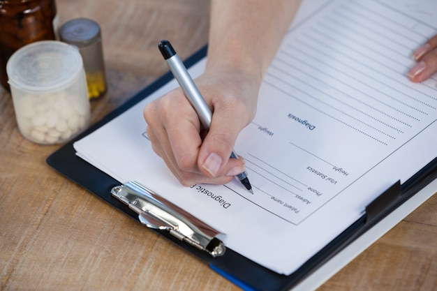 Médecin rédigeant un rapport médical