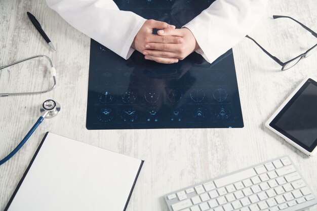 Médecin regardant une photo radiographique de la tête.