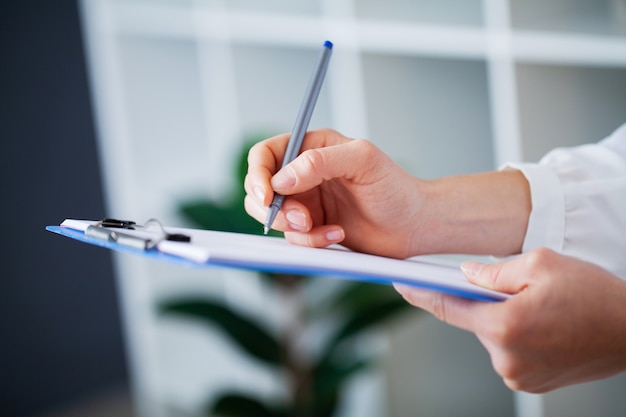 Le médecin remplit la carte du patient après l'examen