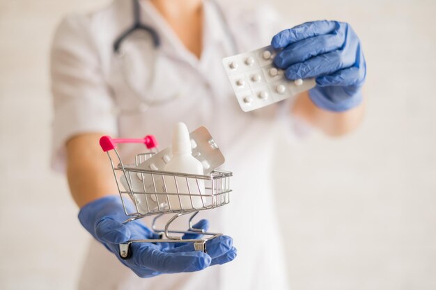 Un médecin sans visage met une plaquette de pilules dans un mini panier