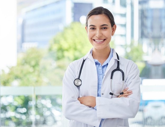 Médecin de santé ou infirmière femme avec stéthoscope à l'hôpital bokeh et heureux avec le sourire Confiance en santé et mission expert médical professionnel ou travailleur avec motivation et vision du bien-être