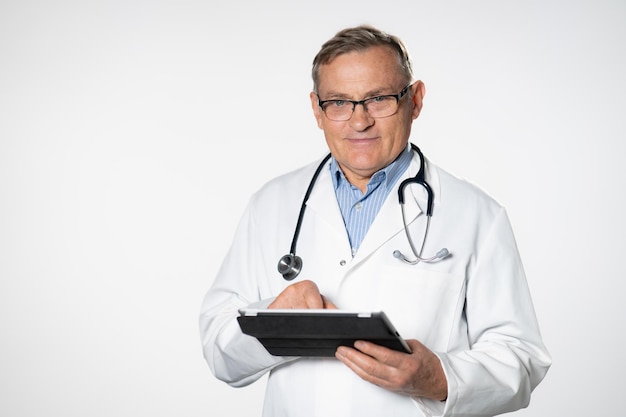 Médecin scientifique senior à l'aide de son ordinateur tablette au travail fond blanc