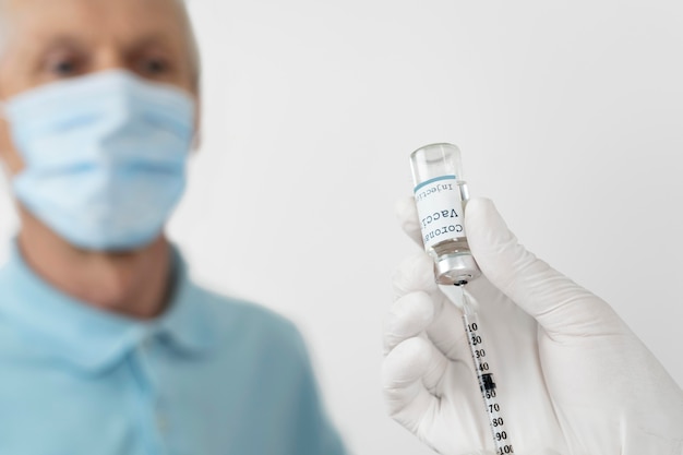 Médecin se préparant à administrer un vaccin à un patient masculin