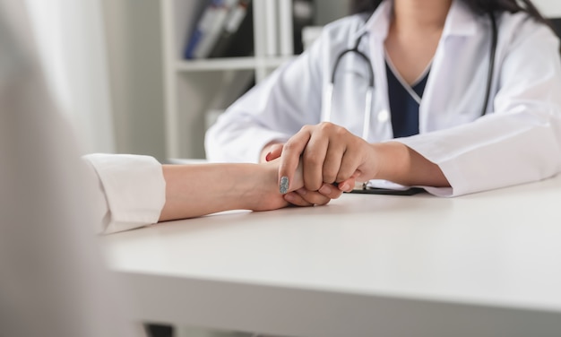 Le médecin se tient la main pour réconforter et encourager le patient.