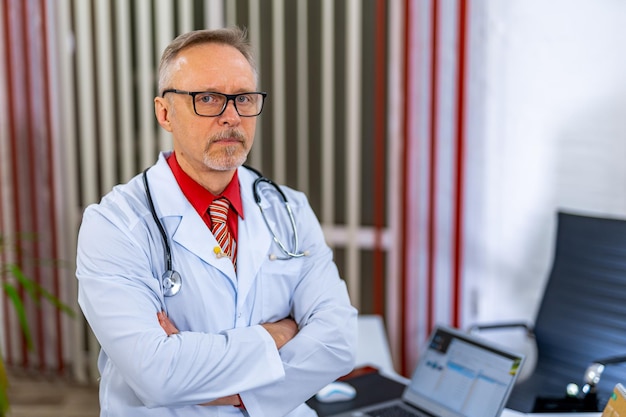 Photo médecin se tient les mains croisées dans les gommages médicaux médecin dans des verres au bureau gros plan concept médical