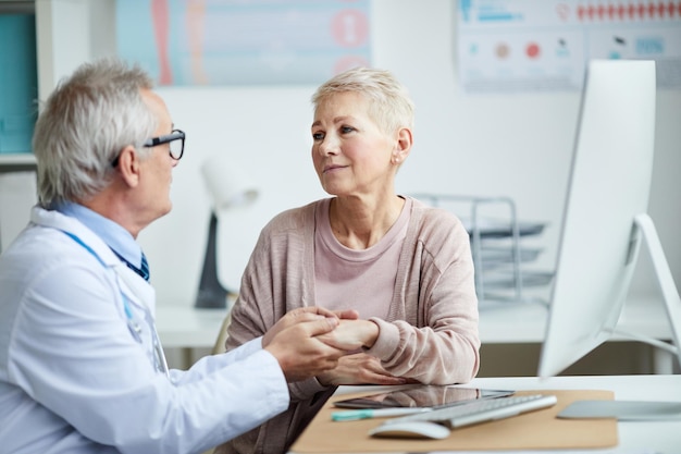 Médecin senior donnant espoir et réconfort au patient