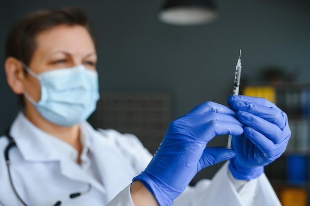 Médecin avec une seringue médicale dans les mains se prépare pour l'injection