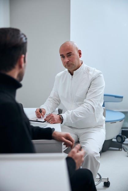 Médecin de sexe masculin consultant guy dans une clinique moderne