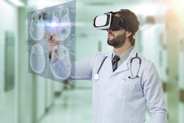 Médecin de sexe masculin dans un hôpital, à l'aide de lunettes de réalité virtuelle, regardant un écran virtuel