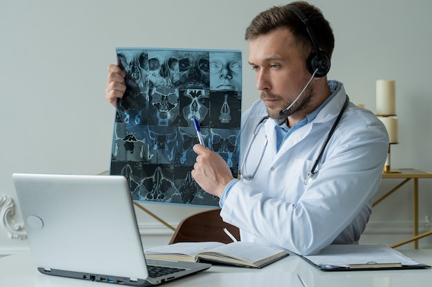 Médecin de sexe masculin à l'écoute du patient au cours de la séance de télémédecine.