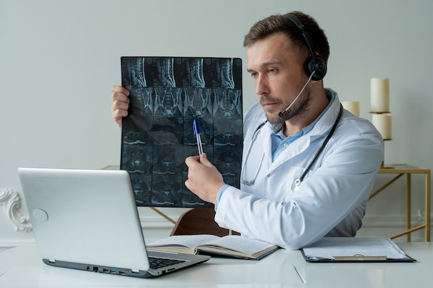 Médecin de sexe masculin à l'écoute du patient au cours de la séance de télémédecine.