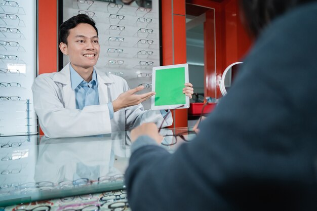 Un Médecin De Sexe Masculin Montre Une Planche De Test De Couleur Qui Est L'une Des Bases Des Examens De La Vue Dans Une Clinique Ophtalmologique