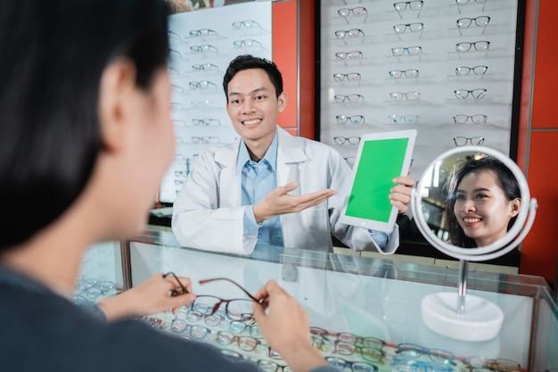 Un médecin de sexe masculin montre une planche de test de couleur qui est l'une des bases des examens de la vue dans une clinique ophtalmologique