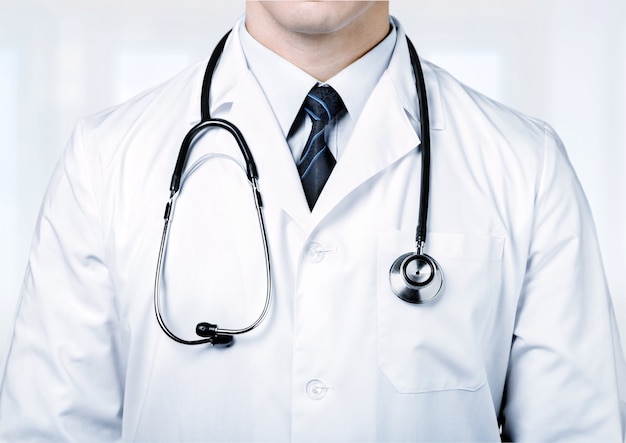 Médecin de sexe masculin avec stéthoscope sur fond flou de l'hôpital