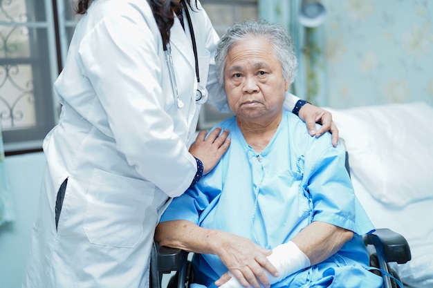 Médecin soigner, aider et soutenir une patiente âgée en fauteuil roulant à l'hôpital.