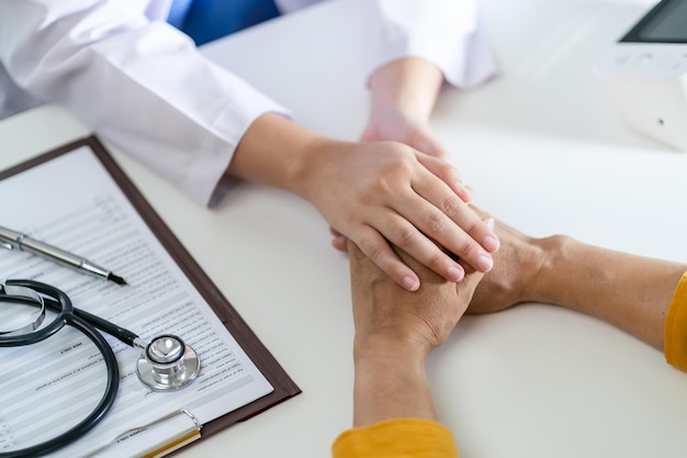 Médecin soins de santé Médecin professionnel en uniforme blanc robe manteau interview consultant patient rassurant son patient masculin main d'aide