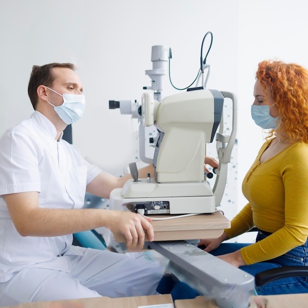 Un médecin et son patient lors d'un examen de la vue à l'aide d'un autoréfracteur