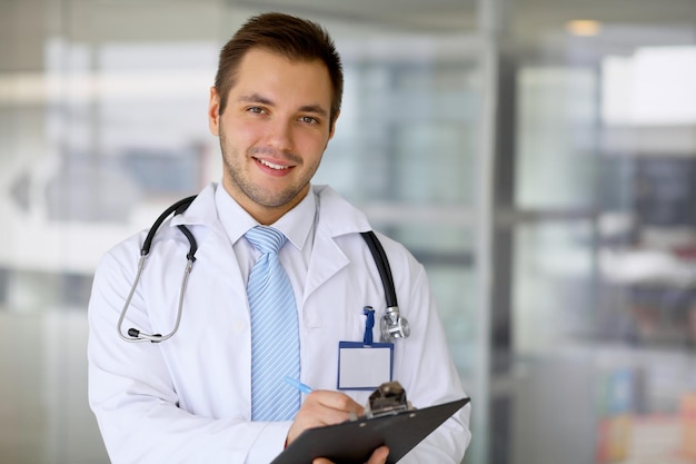 Médecin souriant attendant son équipe en se tenant debout