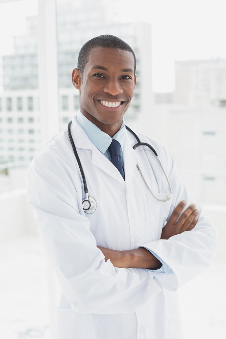 Photo médecin souriant avec les bras croisés dans un cabinet médical