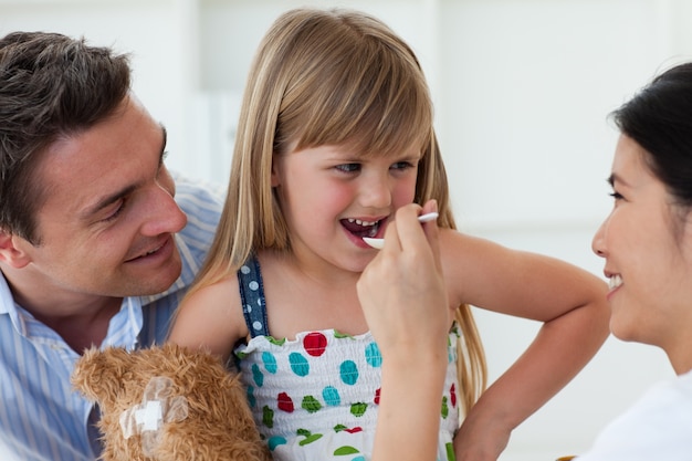 Médecin souriant donnant la médecine à un enfant