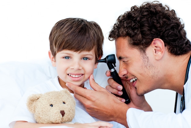 Médecin souriant examinant les oreilles du patient