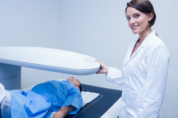 Médecin souriant avec un patient sous une machine à rayons X