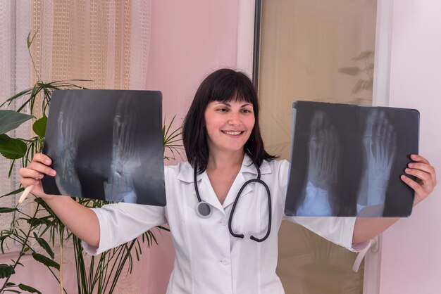 Médecin souriant avec la radiographie du patient dans les mains