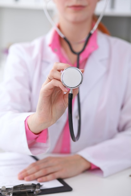 Médecin avec un stéthoscope dans les mains. Scène de couleur rose