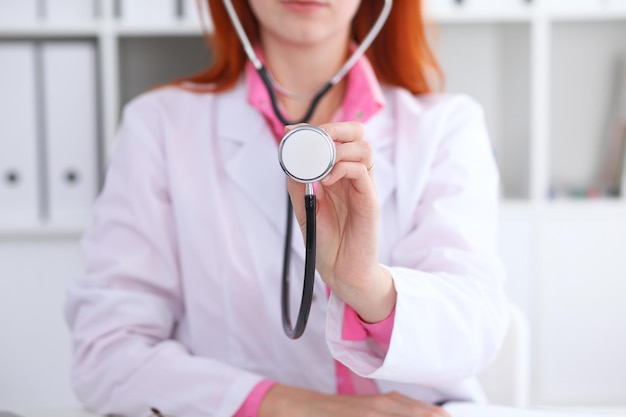 Médecin avec un stéthoscope dans les mains. Scène de couleur rose