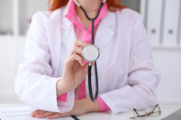 Médecin avec un stéthoscope dans les mains. Scène de couleur rose