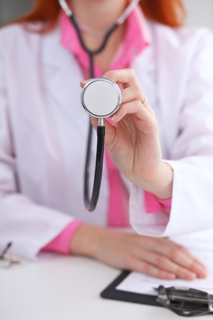 Médecin avec un stéthoscope dans les mains. Scène de couleur rose