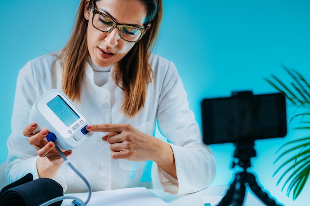 Médecin de télésanté enregistrant des instructions vidéo pour le patient et montrant comment mesurer la glycémie