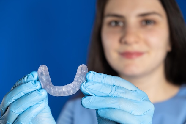 Photo médecin tenant une attelle de protège-dents dentaire pour le traitement du dysfonctionnement de la malocclusion du bruxisme des articulations temporo-mandibulaires pour détendre les muscles de la mâchoire