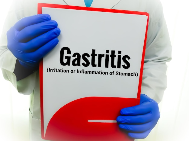 Médecin tenant un bloc-notes avec terme médical gastrite inflammation de l'estomac