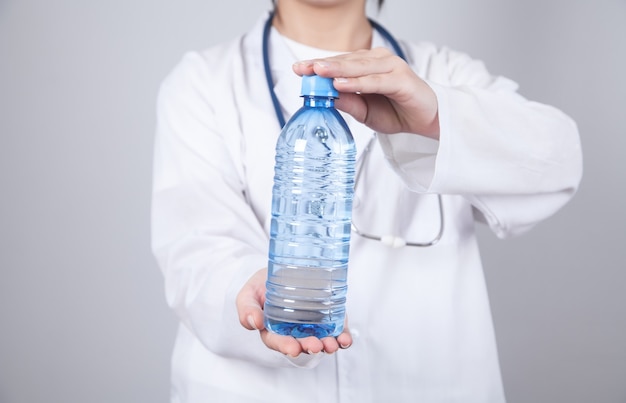 Médecin tenant une bouteille d'eau.