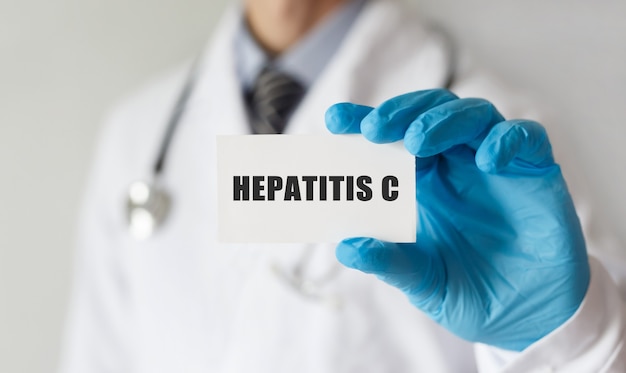 Médecin tenant une carte avec texte HEPATITE C, concept médical