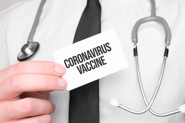 Médecin tenant une carte avec texte Vaccin contre le coronavirus, concept médical