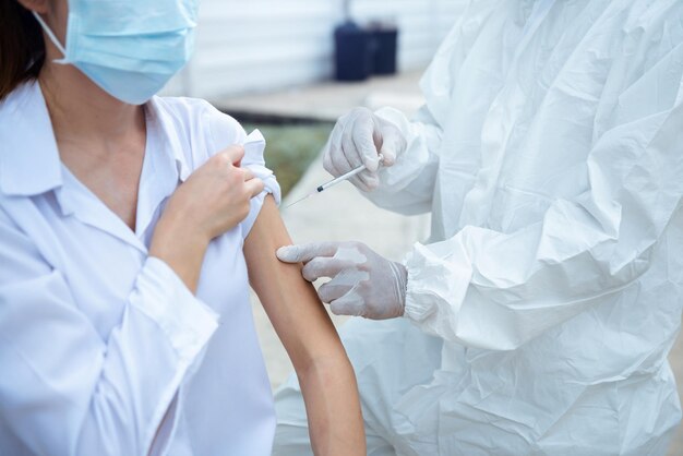 Médecin tenant une seringue avant de faire une injection au patient dans un masque médical. Vaccin Covid-19 ou coronavirus