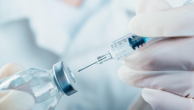 Médecin tenant une seringue avec un seul flacon de vaccin Covid19 pour enfants ou adultes Concept lutte contre le virus Gros plan détail Concept médical vaccination traitement par injection hypodermique