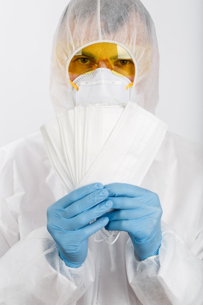 Un médecin en tenue anti-épidémique détient des masques médicaux pour se protéger contre le virus