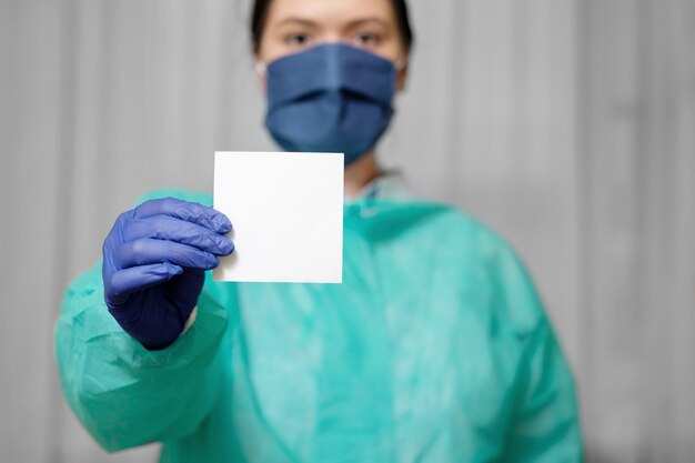 Médecin tient un morceau de papier pour le texte, restez à la maison, appel du médecin dans l'épidémie de coronavirus