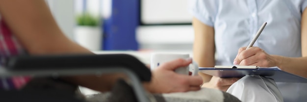 Le médecin tient le presse-papiers avec les antécédents médicaux du patient sur rendez-vous